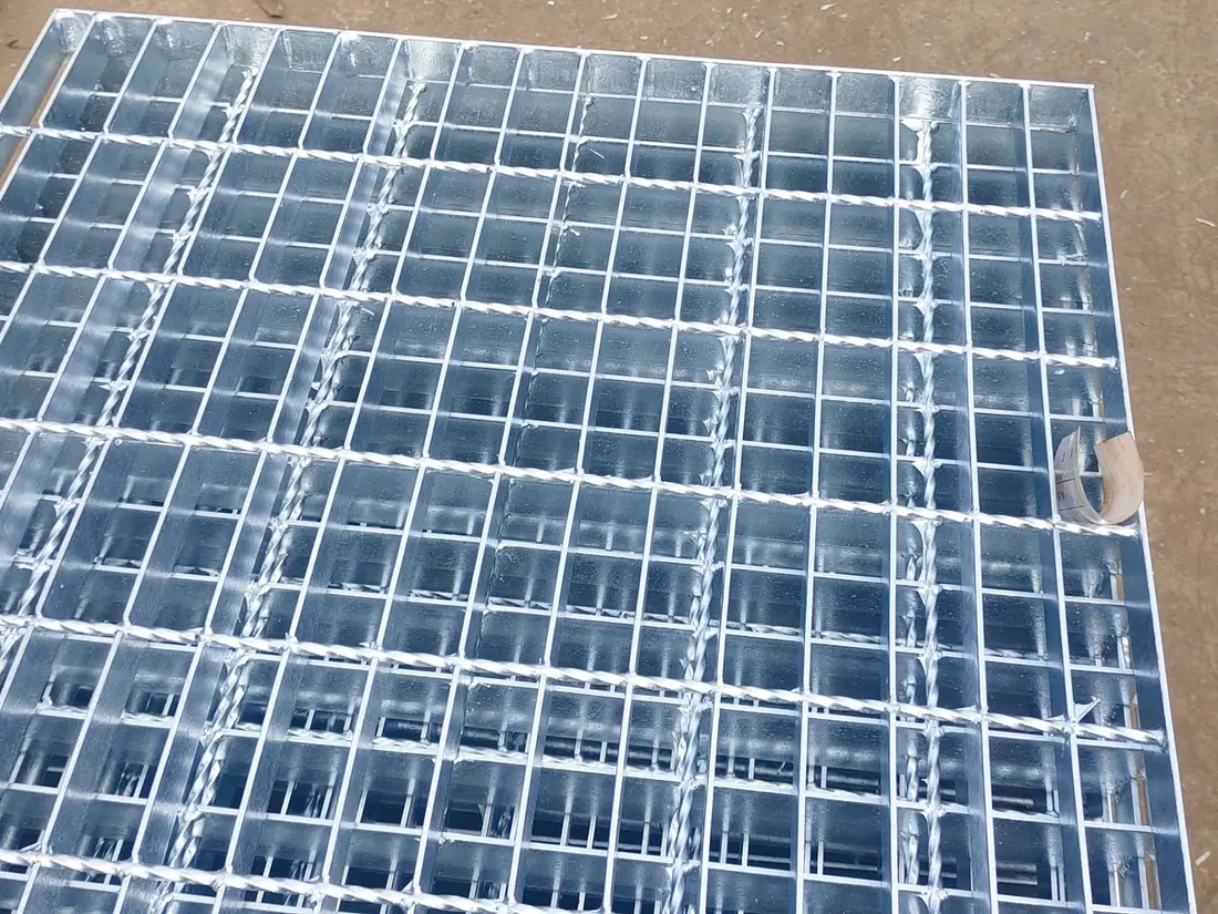 Steel grating press-locking workshop at Anping Hand in Hand factory, bearing bars and cross bars fed into the hydraulic press for industrial walkway panels