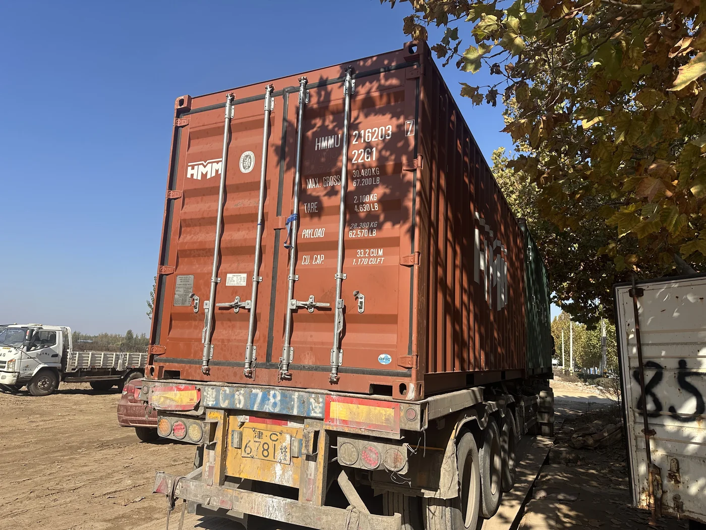 Anping Hand in Hand workshop — red container on flatbed trailer at outdoor loading area, ready for loading